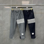 Pantaloni jogger sportivi grigi e navy con strisce bianche, elastici e stile casual.