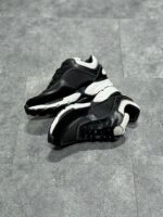 Scarpe sportive nere e bianche, comfort, stile urbano, suola performante e design moderno.