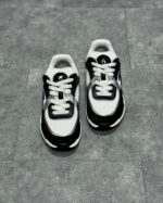 Sneakers sportive bianche e nere, comfort e stile, suola antiscivolo, design moderno e dinamico.