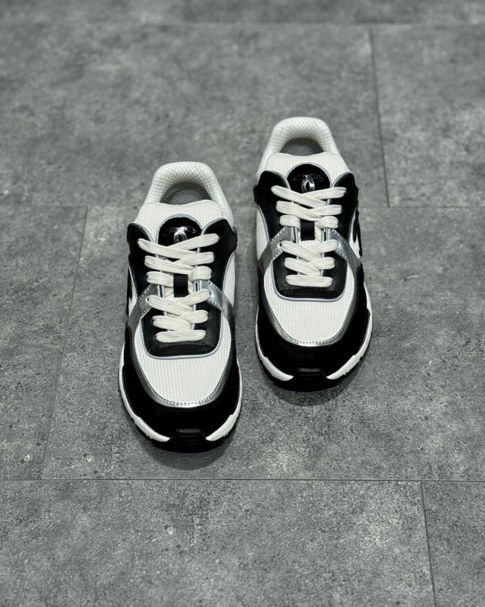 Sneakers sportive bianche e nere, comfort e stile, suola antiscivolo, design moderno e dinamico.
