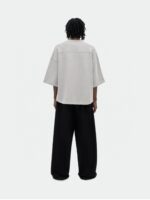 Persona da behind con look urbano casual, top oversize e pantaloni larghi, hairstyle naturale twist.