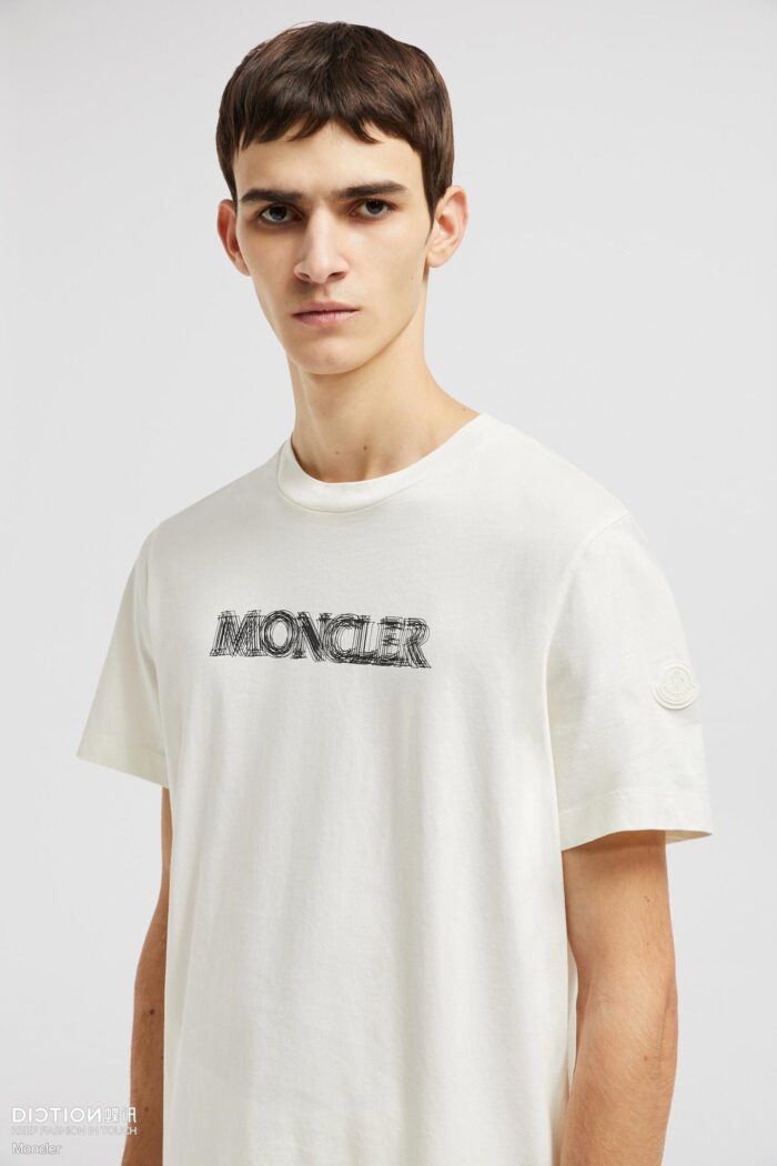 Giovane uomo in t-shirt Moncler, stile casual e raffinato, brand visibile sul petto.