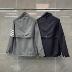 Giacche moderne casual e sportiva con dettagli flap, in grigio e nero, sullo sfondo a piastrelle.