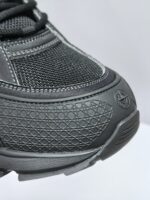 Sneaker nera moderna in tessuto e sintetico con protezione, grip e logo discreto per sport e casual.