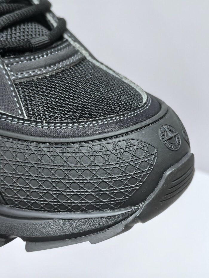Sneaker nera moderna in tessuto e sintetico con protezione, grip e logo discreto per sport e casual.
