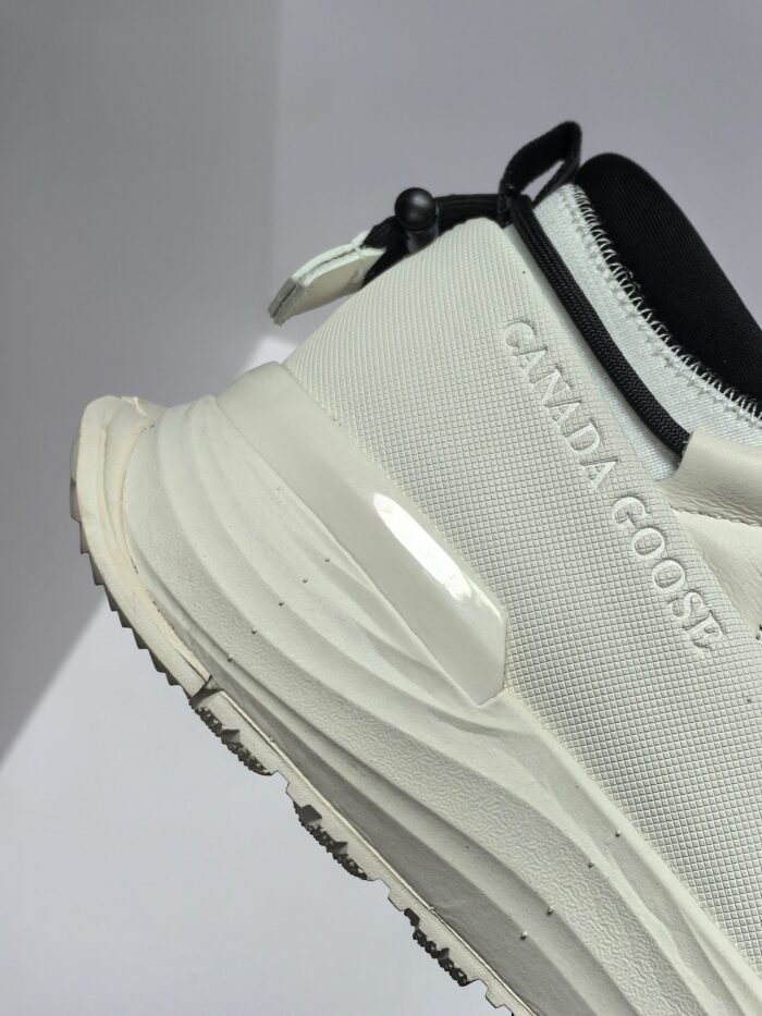 Scarpa bianca sportiva Canada Goose con dettagli moderni, logo in rilievo e suola antiscivolo.