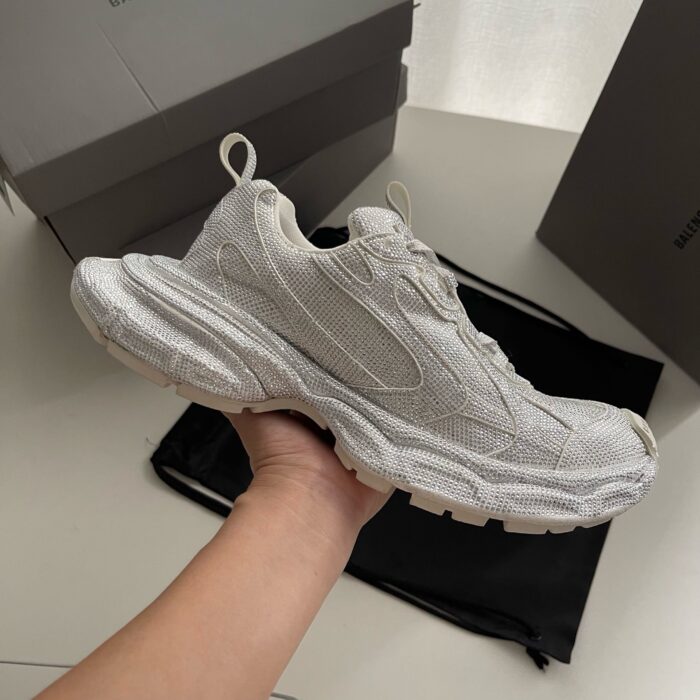 Sneaker bianca moderna con suola chunky, design minimalista e traspirante, perfetta per stile e comfort.