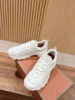 Sneakers bianche moderne su superficie di legno, stile sportivo e casual, design elegante e versatile.
