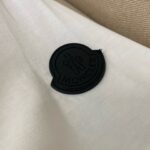 Logotipo Moncler su patch nero, elegante e di alta qualità su tessuto chiaro.