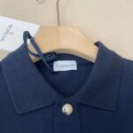 Maglia polo Moncler blu navy, elegante e di qualità, con dettaglio metallici e logo distintivo.