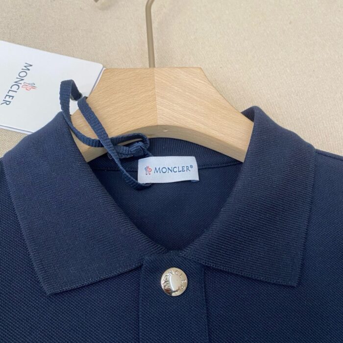 Maglia polo Moncler blu navy, elegante e di qualità, con dettaglio metallici e logo distintivo.