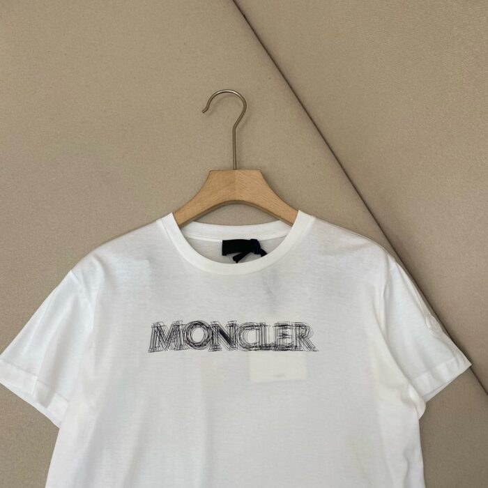 Maglietta bianca Moncler logo moderna, stile casual, tessuto di alta qualità su appendiabiti.