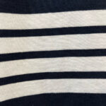 Tessuto a righe navy e crema, stile marinaro, perfetto per capi casual e classici.