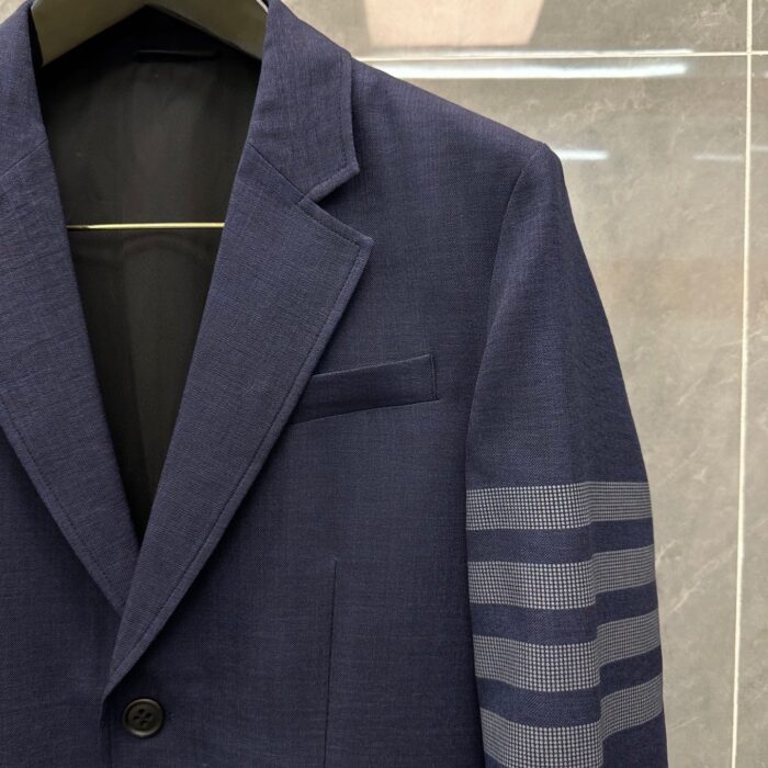 Blazer navy blu elegante con dettaglio moderno a manica a strisce e cuciture precise.