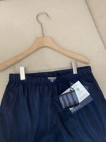 Pantaloncini nautici navy sportivi con logo triangolare, elastici e tessuto leggero.