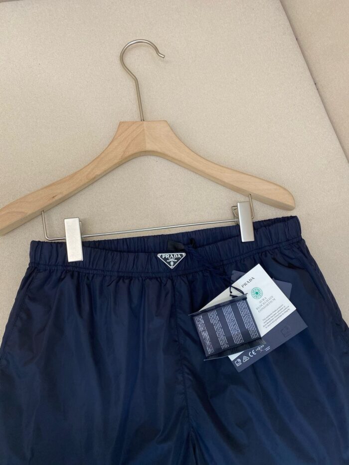 Pantaloncini nautici navy sportivi con logo triangolare, elastici e tessuto leggero.