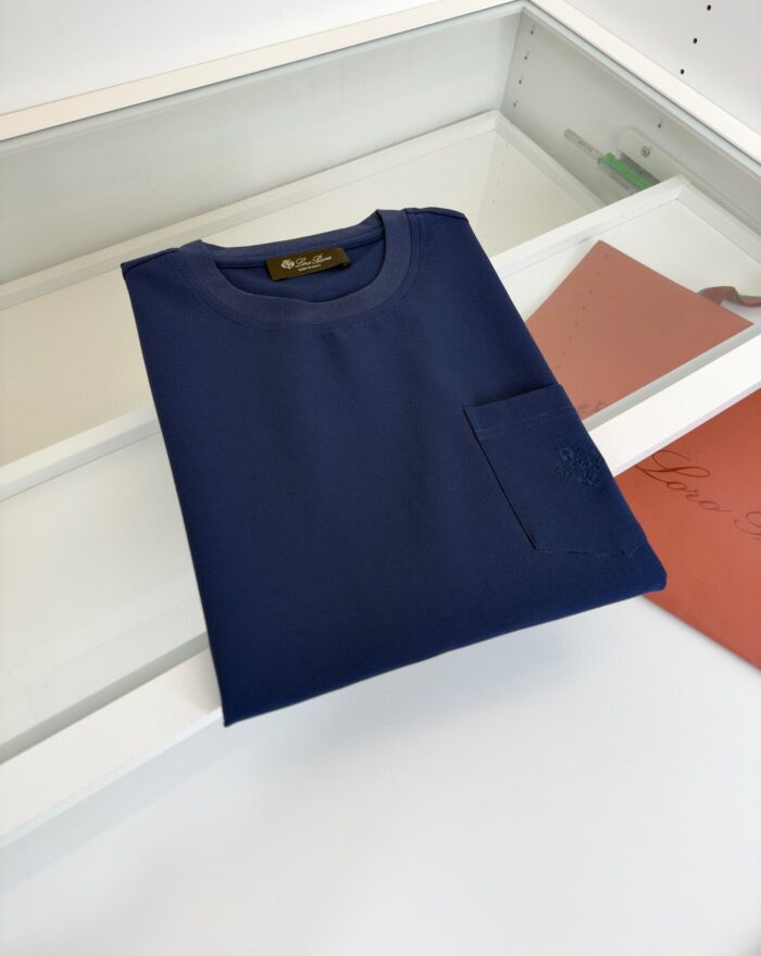 Maglietta navy blu con tasca, stile casual e qualità, su sfondo bianco minimalista.