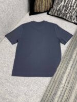 T-shirt casual navy su divano con cuscini decorativi, stile minimalista e comfort domestico.
