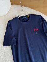 T-shirt navy blue con ricamo di figure rosse e logo circolare, stile casual versatile.