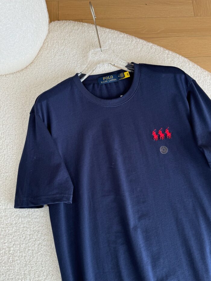 T-shirt navy blue con ricamo di figure rosse e logo circolare, stile casual versatile.