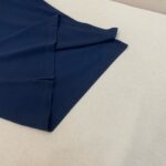 Tessuto blu navy morbido, leggero, con pieghe eleganti e finitura accurata.