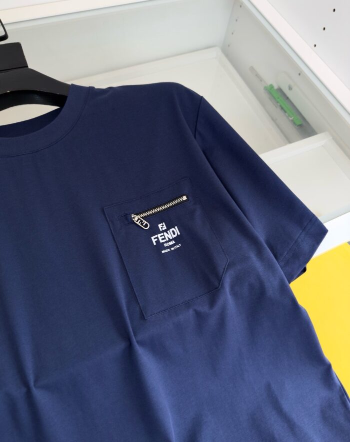 Maglietta Fendi navy con tasca con zip e logo bianco, stile casual elegante.