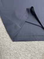 Dettagli tessuto e cuciture di una camicia navy blue, stoffa morbida e rifinita con cura.