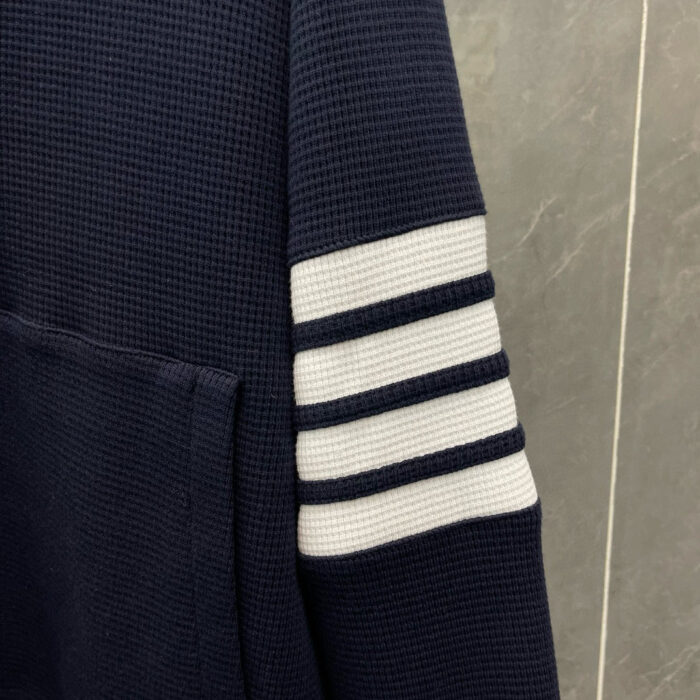 Felpa navy con strisce bianche, tasca frontale e design sportivo casual.