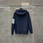 Felpa navy con cappuccio, strisce bianche sulle maniche, stile sportivo casual.
