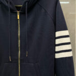 Felpa navy blu con strisce bianche, zip dorata e tasca frontale, stile sportivo e casual.