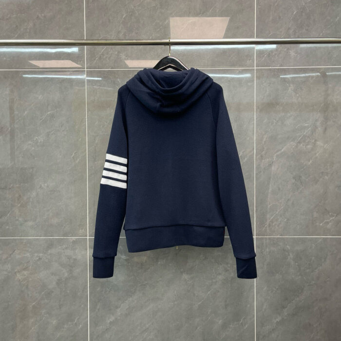 Felpa navy blue con cappuccio, strisce bianche sulle maniche, stile casual e sportivo.