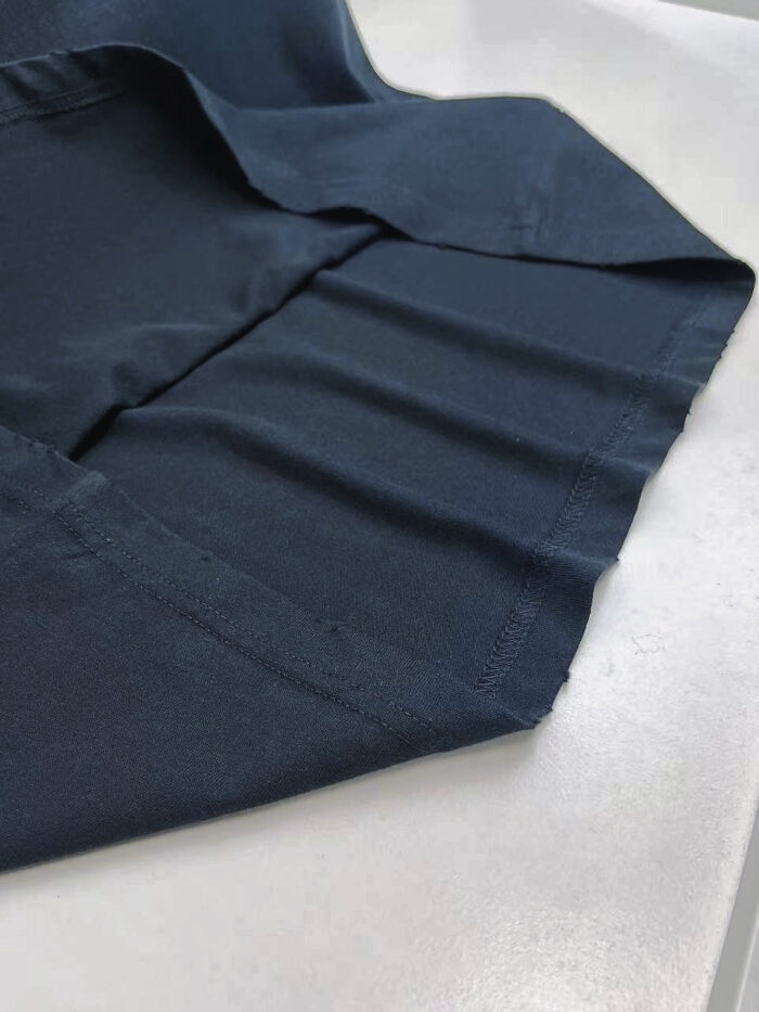 Tessuto navy blue con pieghe eleganti e finiture di alta qualità, ideale per moda e design.