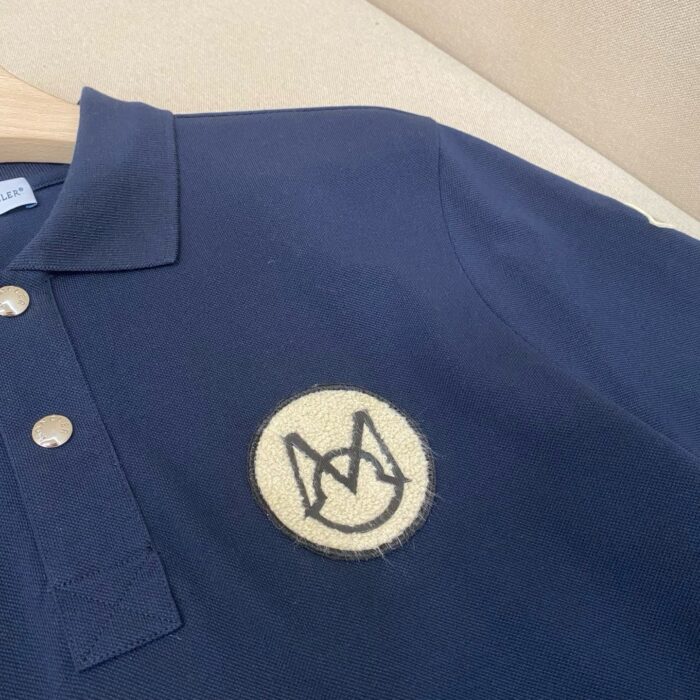 Maglietta polo navy con logo ricamato in crema, tessuto testurizzato, stile casual ed elegante.