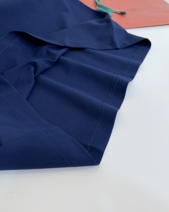 Tessuto seta navy blue elegante, morbido, piegato con dettagli di cucitura e etichetta.