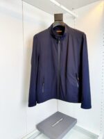 Giacca navy blu minimalista con zip, stand-up collar e stile moderno su manichino.