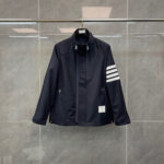 Giacca sportiva blu navy con strisce bianche, stile minimalista e dettagli pratici.