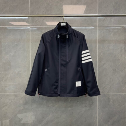 Giacca sportiva blu navy con strisce bianche, stile minimalista e dettagli pratici.