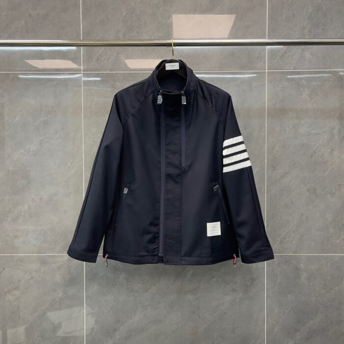 Giacca sportiva blu navy con strisce bianche, stile minimalista e dettagli pratici.
