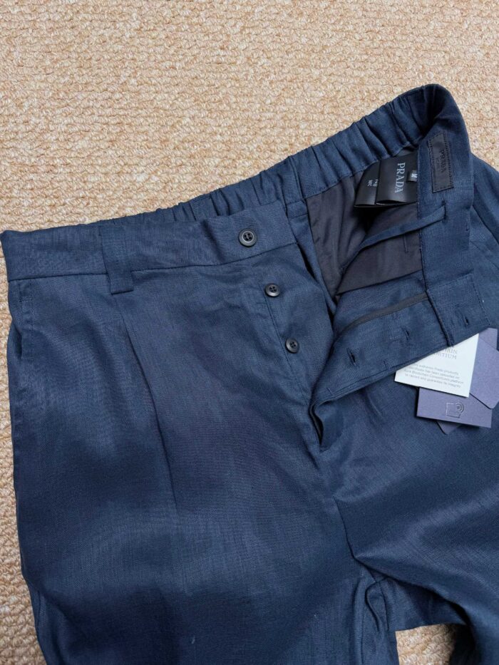 Pantaloni navy elasticizzati con doppio bottone e dettagli rifiniti, stile versatile e confortevole.
