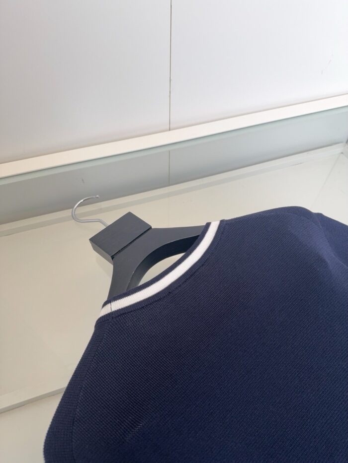 Maglia navy con colletto bianco, stile semplice ed elegante, da appendere con gancio nero.