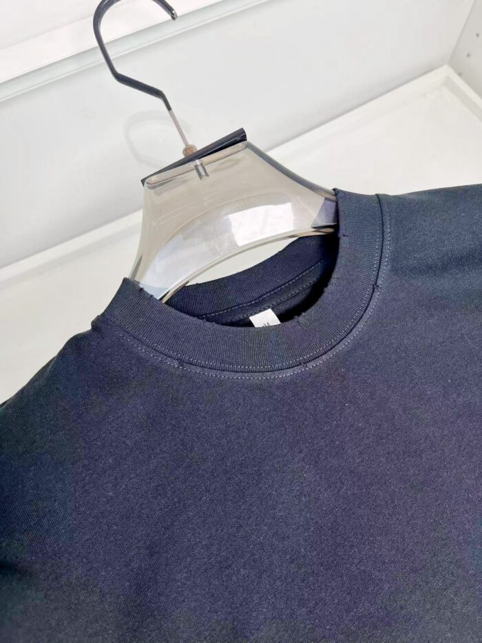 Felpa nera casual con collo a costine, elegante e comoda, su appendiabiti trasparente.