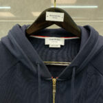 Felpa navy Thom Browne con zip, dettagli di lusso, stile moderno e alta qualità.