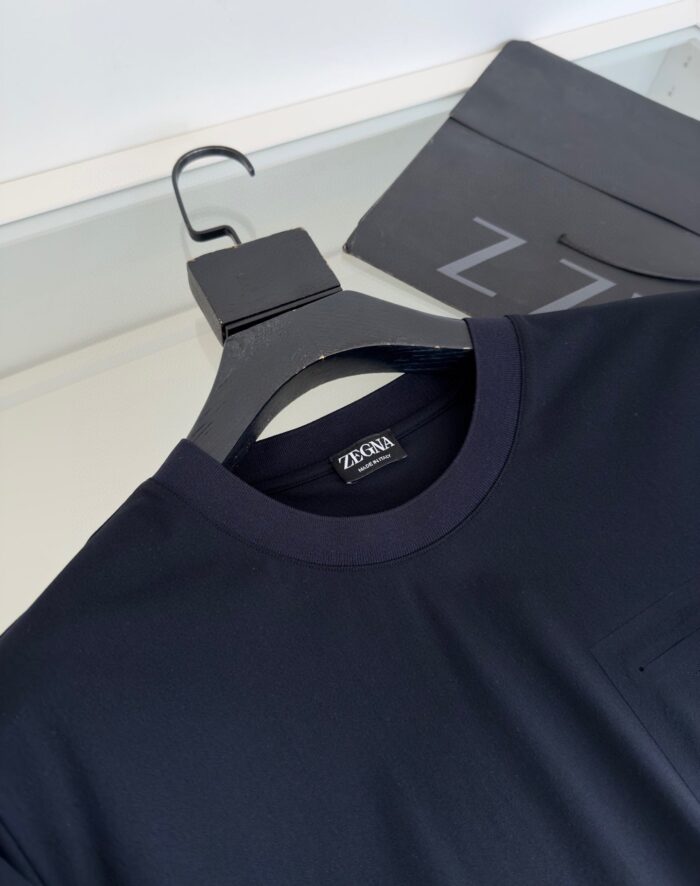 Maglietta navy blue con tasca, stile elegante e di alta qualità, su gancio nero.