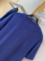 Maglietta navy blue casual ed elegante su appendiabiti in un ambiente raffinato.