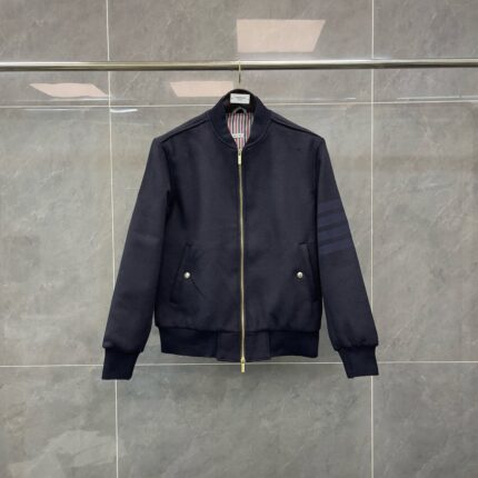 Giacca bomber navy con zip oro, dettagli eleganti e lining a righe, stile contemporaneo.