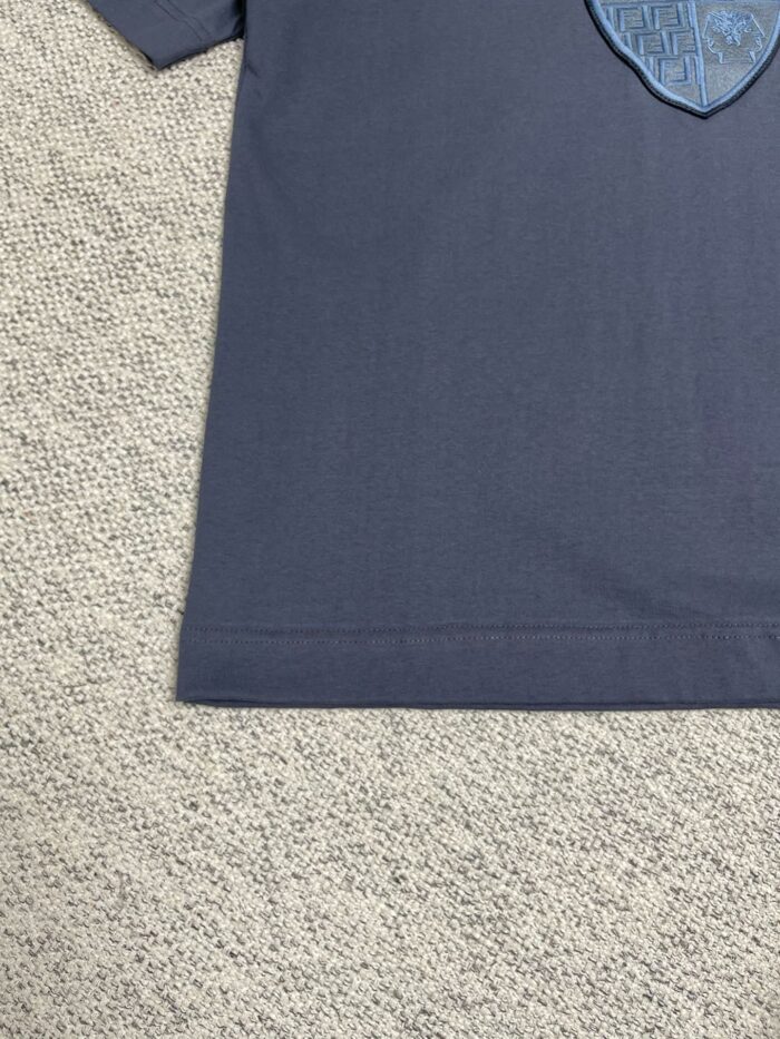 Maglietta navy con emblema a scudo in cotone, stile casual ed elegante.