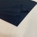 Tessuto navy di alta qualità, elegante e versatile per moda e decorazione, cuciture precise e rifinite.