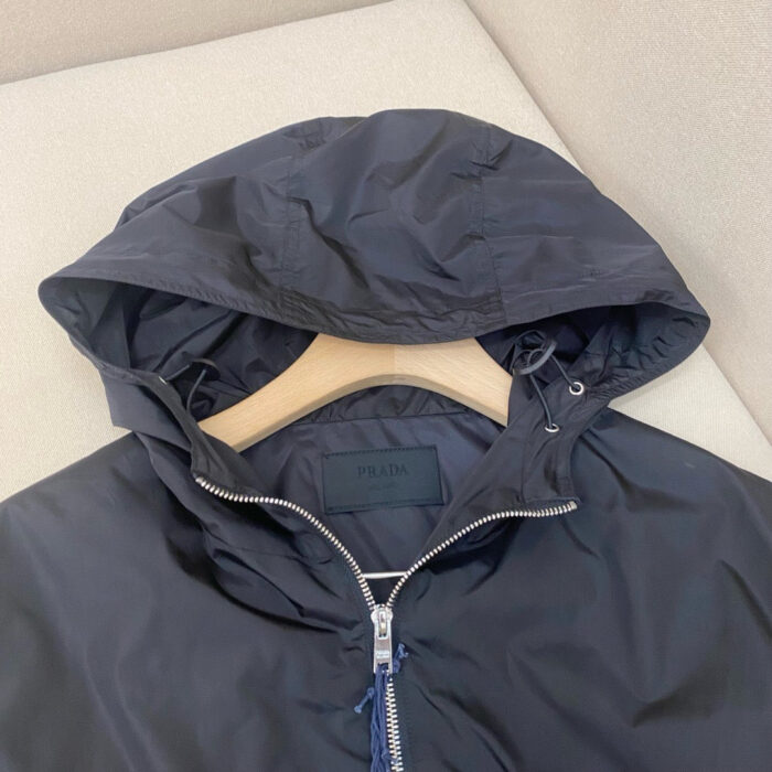 Giacca navy con cappuccio e zip, stile moderno e resistente allacqua per uomo.