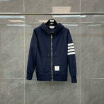 Felpa navy con zip frontale e dettagli a strisce bianche, stile sportivo e moderno.