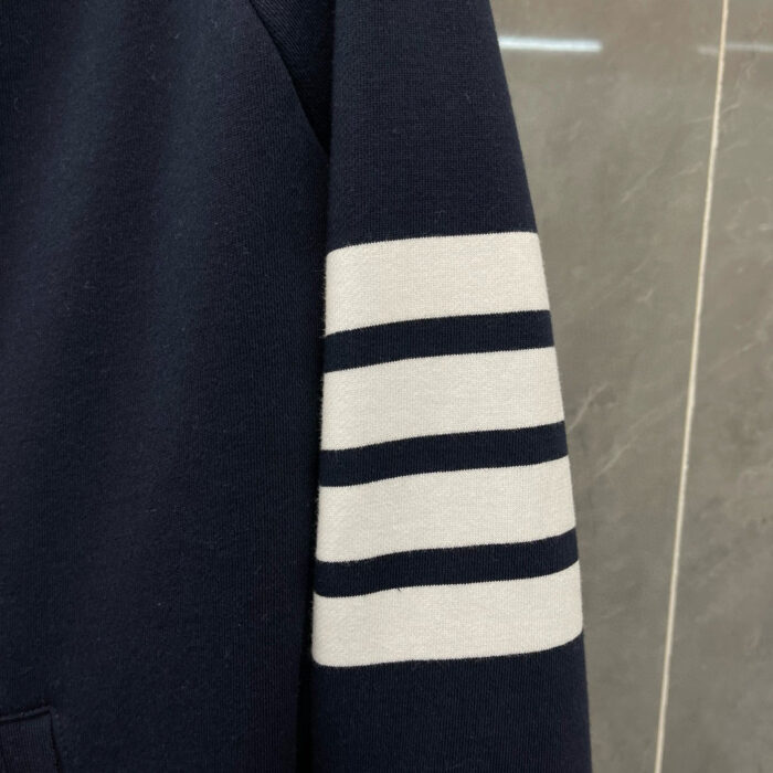 Manica di felpa navy con banda grigia a righe per uno stile casual elegante.